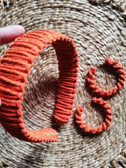 A matching set of a tangerine orange macrame hairband and spiral hoop earrings. This vibrant color is perfect for making a statement.
