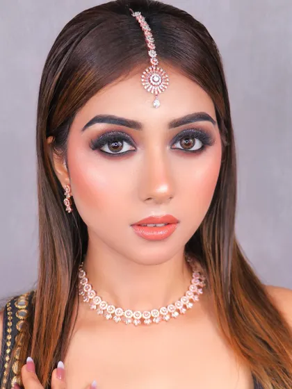 The intensity of this glittery eye look is perfectly balanced with a simple necklace and maang tikka, showcasing our student's eye for detail.