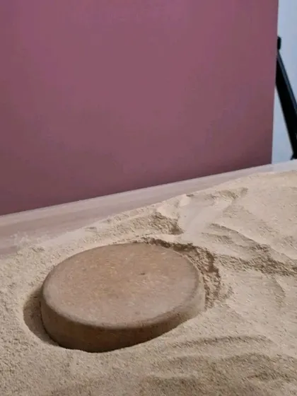 Using a prop to create a perfect circular base in the sand for the product to sit on.