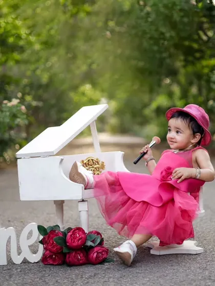 Who says a one year old can't be a little diva? We love getting creative with our outdoor shoots, like this adorable mini piano setup. It’s all about capturing their budding personality in a playful way.