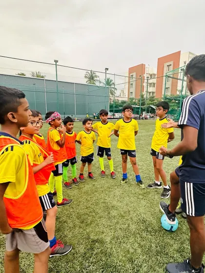 A coach gives a team talk to his players. Communication and strategy are important parts of our curriculum.