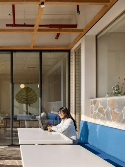 An outdoor-adjacent workspace at the Godrej Woods Clubhouse. This setup allows for a seamless blend of work and nature, providing a refreshing alternative to a traditional office desk.