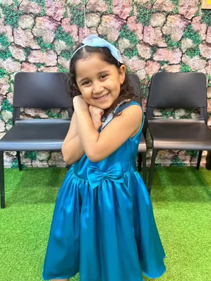 The perfect smile in the perfect blue dress. This satin frock in a brilliant turquoise shade features a sparkly sequin collar and a sweet bow, making her feel confident and happy.