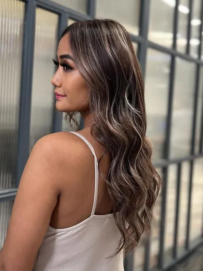 A side profile of a beautiful balayage, showing how the highlights are woven through the hair to create a natural and seamless effect.