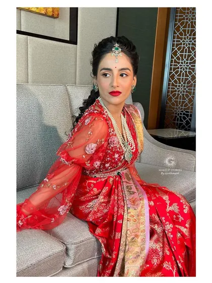 A beautiful shot of this client in a modern red ensemble. The blouse features puffed sleeves with 3D floral embroidery, adding a touch of contemporary flair to her look.