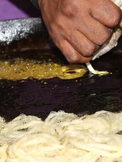 A close-up of our chef frying fresh jalebis, ensuring each one is perfectly golden and crispy for the guests.
