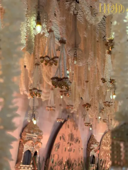 The ceiling of floral chandeliers against the warm glow of the stage, creating a rich and layered visual effect.