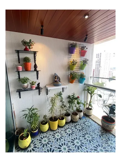 For the other side of the balcony, we created a vertical garden using wall-mounted shelves and grids. This allows for plenty of colorful potted plants without taking up valuable floor space, turning the area into a lush green corner.