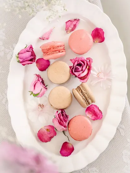 A full flatlay of the macarons and roses on a decorative plate, creating a beautiful and elegant composition.