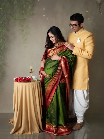 A moment of blessing and prayer. The couple stands by a table with a lit diya, creating a portrait that is both spiritual and deeply personal.