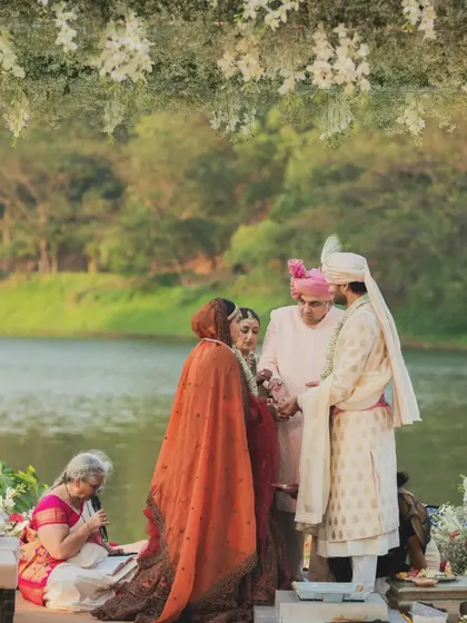 A moment during the wedding ceremony, framed by the floral-draped mandap with a serene lake in the background, showcasing how I integrate natural beauty into the design.