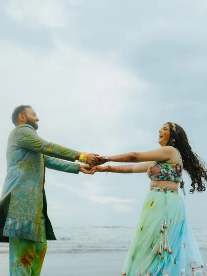 Pure joy and movement as the couple dances on the beach after their Haldi. This candid shot is full of life and captures their carefree spirits.