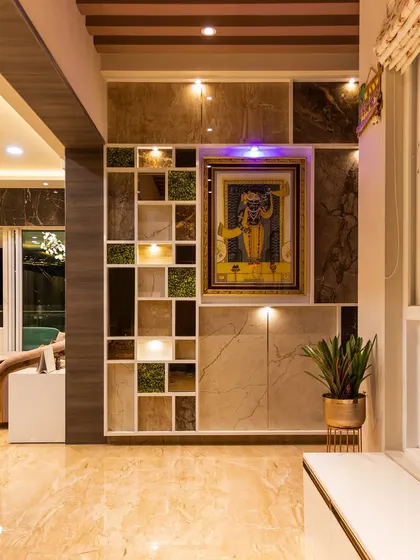 A unique partition wall with built-in display niches, some filled with greenery, adds an artistic and functional element to this luxurious living space.