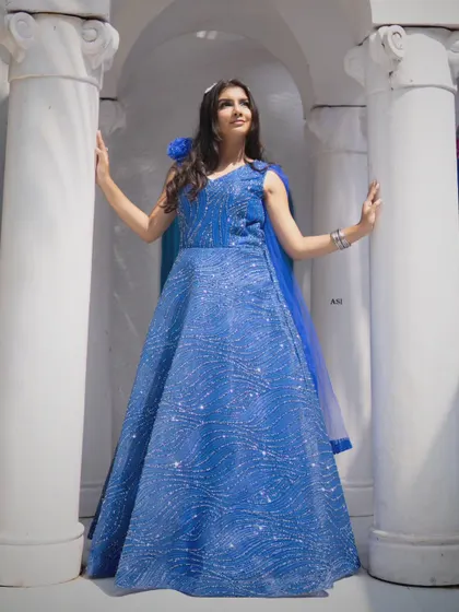 The full silhouette of the blue sequin gown is on display here, showing its classic A-line shape and sparkling details.