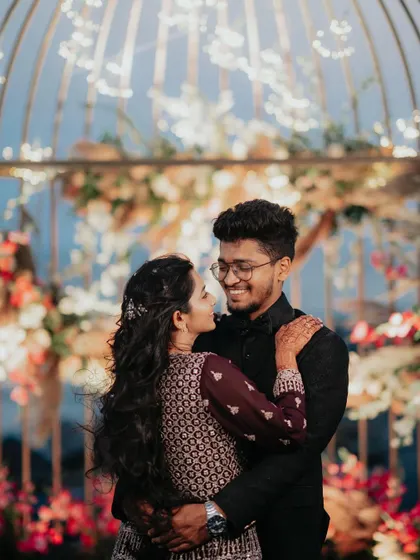 A close-up, romantic shot of the couple in front of the beautifully decorated birdcage prop.