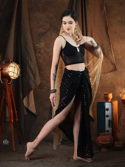 A full-length view of a modern fusion outfit, showing the high-slit skirt and contemporary top. The pose is inspired by classical dance, blending traditional and modern movements.
