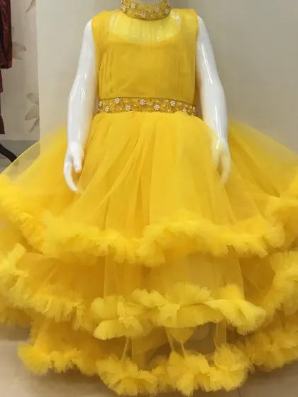 A grand yellow gown with three layers of ruffles and a hand-worked belt and neckline.
