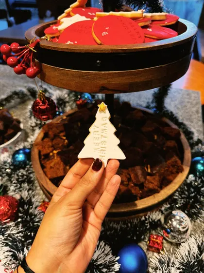 Holding up a custom Christmas tree-shaped cookie from a corporate catering event. It’s all in the little details.
