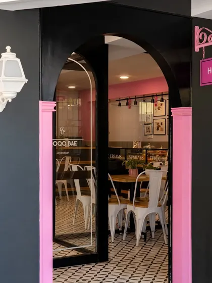 A daytime view of the Qoqobae entrance. The pink accents and whimsical "Hey!" sign add a playful touch, inviting passersby into the charming ice cream parlor.