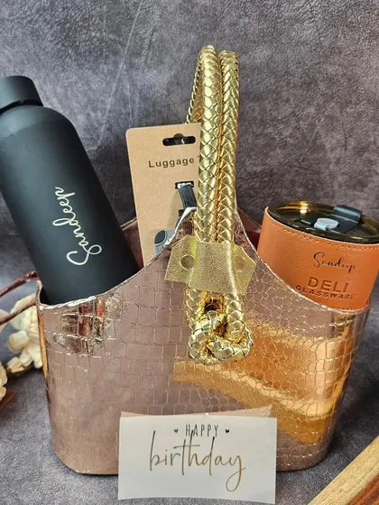 A stylish birthday hamper for him, complete with a personalized bottle, a custom tumbler, and a luggage tag, all packed in a chic basket.