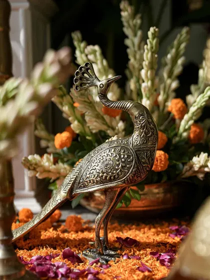 A close-up of an intricately carved brass peacock, a beautiful symbol often used in traditional Indian decor.