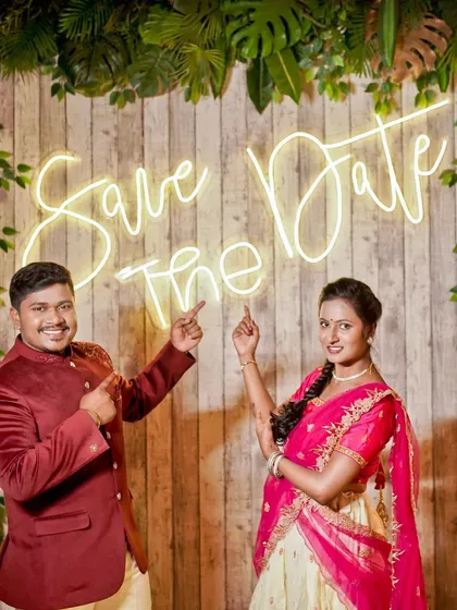 A classic "Save The Date" photo. We help you create the perfect announcement picture with creative backdrops and props like this neon sign.