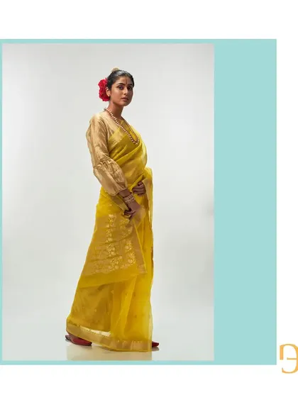 A side profile of the cadmium yellow saree, highlighting its vibrant color and the delicate floral motifs.