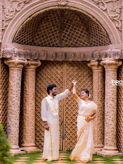 A playful dance in front of an ornate doorway. The couple's matching white and gold outfits and their happy expressions make this a joyful and memorable shot.