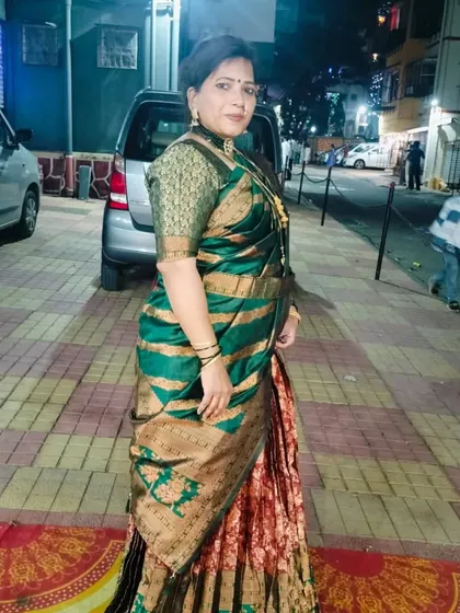 A full-length view of a client in a grand green and gold Paithani Nauvari. This style is perfect for making a statement at weddings or festive celebrations.