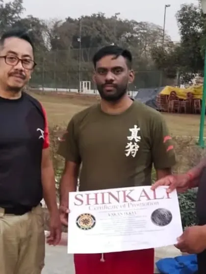 A student receiving his SHINKALI certificate of promotion from me and Sensei E.