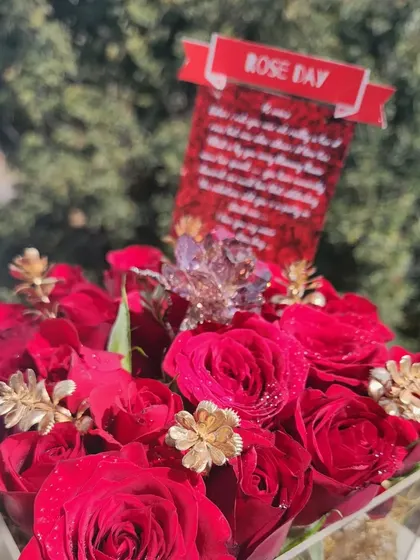 A close-up of the custom card and Swarovski crystal rose in our Rose Day acrylic box arrangement.