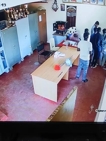 A camera feed from inside the school's main office, showing the staff area.