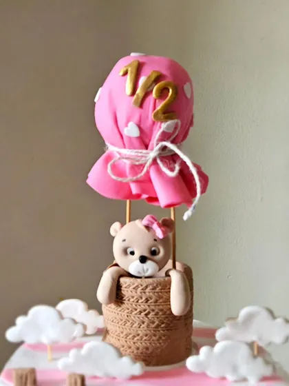 A tight shot of the hot air balloon topper, complete with a tiny teddy bear peeking out.