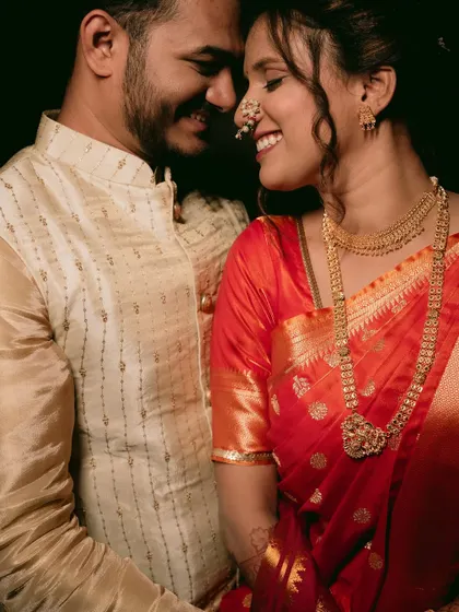 A classic romantic portrait of a couple in traditional Maharashtrian wedding attire, sharing a happy, intimate moment.