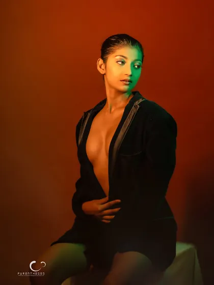 A confident and direct portrait. Her gaze is strong, and the creative lighting adds a unique, artistic flair.