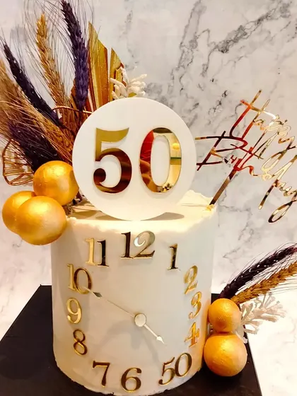 A creative cake for a 50th birthday, designed to look like a clock. The numbers on the clock face mark the years, making it a meaningful and elegant design.