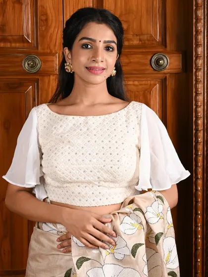 An elegant white blouse with flared, sheer sleeves, offering a breezy and stylish look.
