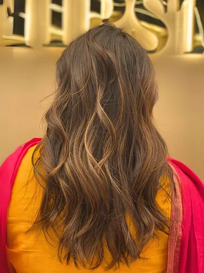The back of a client's hair after a fresh haircut, styled with soft waves to showcase the new layers and shape.