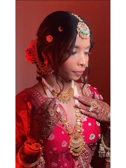 A side profile showcasing the elegant hairstyle and intricate jewellery placement. The soft curls framing her face add a touch of romance to this traditional bridal look.
