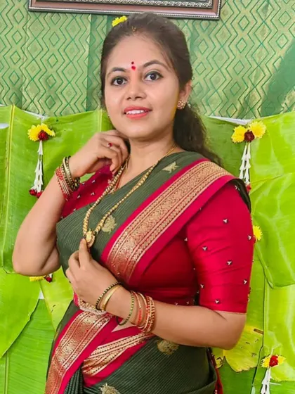 A portrait of the bride in her Haldi ceremony outfit, a lovely green saree with a contrasting pink embroidered blouse.