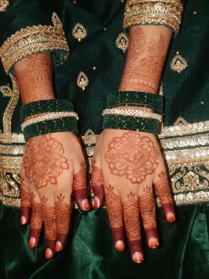 A traditional look for Eid, with simple mandala mehendi paired with green bangles and a festive outfit.