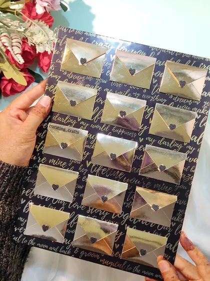 Holding the panel of shiny golden envelopes.
