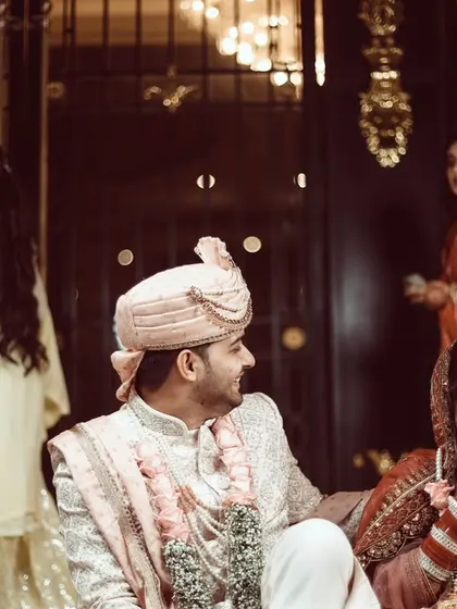 A candid moment of the couple and their family enjoying the playful joota churai tradition.