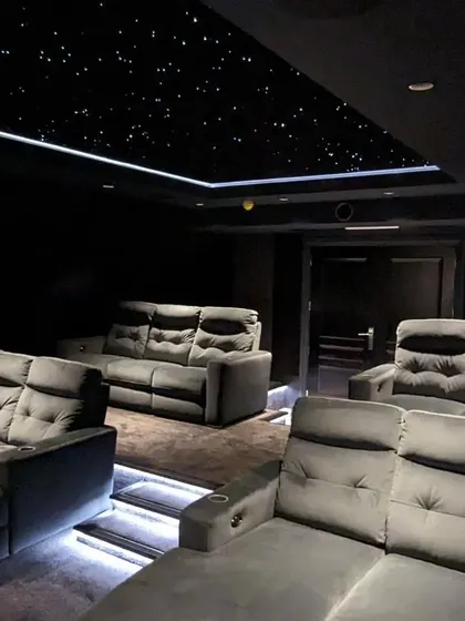 Another angle of the grey-themed theater, showing the comfortable, multi-person sofas that are great for family movie nights.