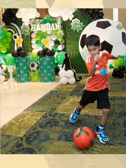 The birthday boy enjoying a kickabout in front of his amazing party setup.