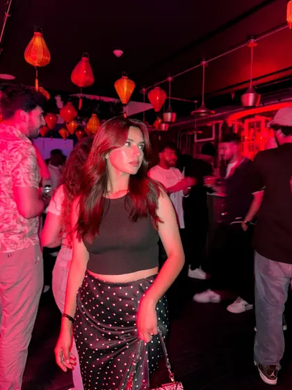 Out and about at a bar with cool red lighting, capturing the nightlife vibe.
