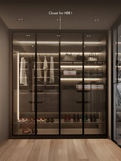 The 'Hers' section of the bespoke closet, designed with ample space for handbags, shoes, and clothing. The warm lighting and glass doors turn a functional storage area into a luxurious display.