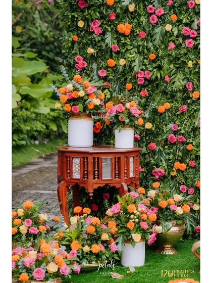 A simple yet elegant detail from the Haldi decor. A colorful floral arrangement in a rustic jar, placed on a wooden table, creates a charming and picturesque vibe.