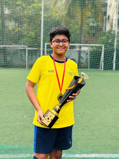 A player from our U13 team with the BEL Cup winner's trophy.