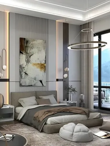 This master bedroom boasts a stunning view with floor-to-ceiling windows. The design is kept modern and minimal, with abstract art and unique light fixtures adding a touch of personality.